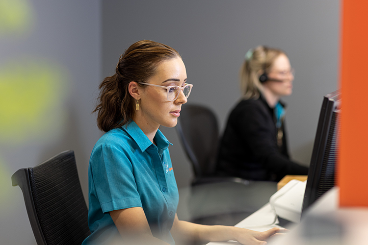 Women sitting at the reception desk wearing glasses typing on a keyboard